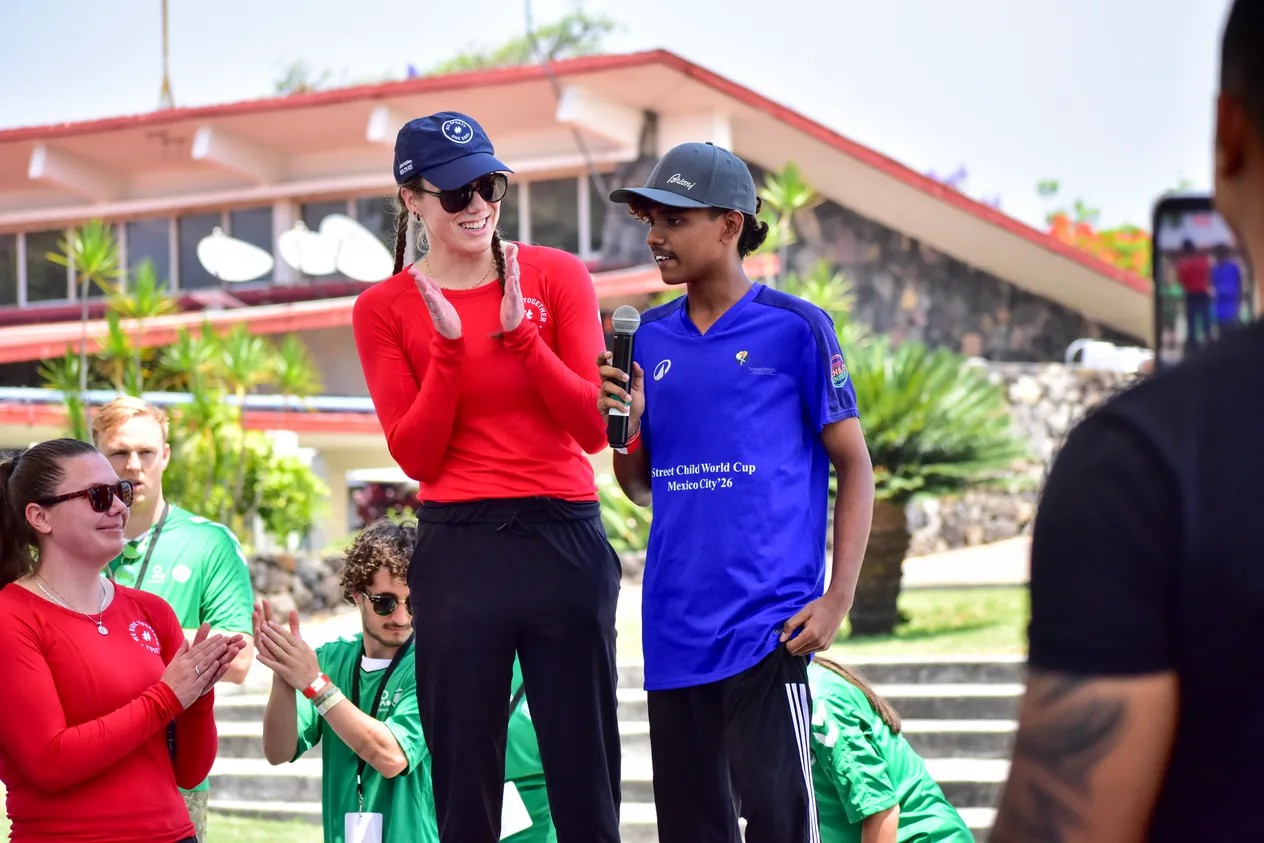 A #WeRideTogether team member speaking with a young athlete at an All Sports, One Goal event